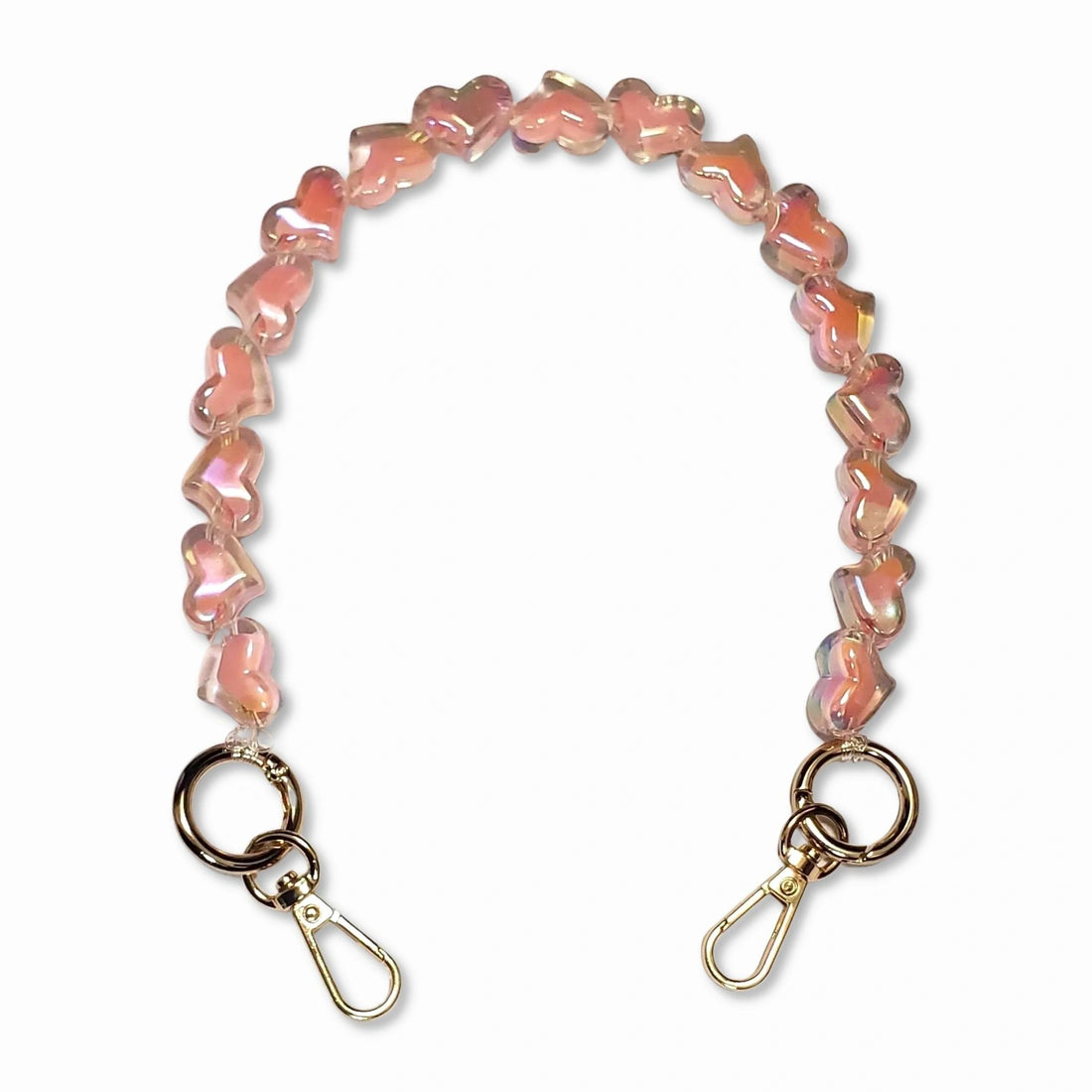 A short bead chain with golden carabiners and a glittery heart charm in light pink color. The chain is designed to be attached to a phone case and can be worn around the wrist for a playful and eye-catching look. The chain is made by The American Case and is designed to be durable.
