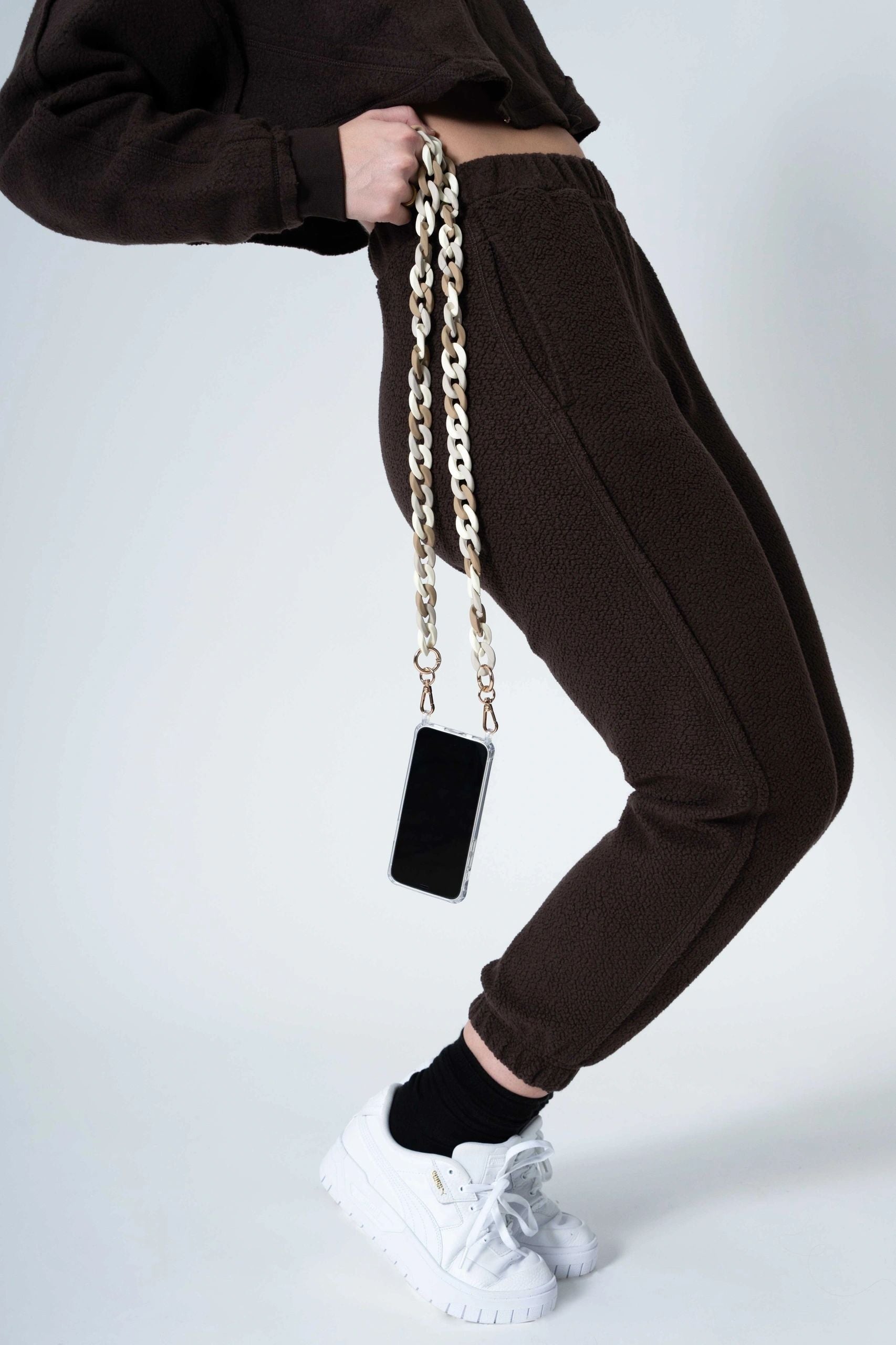 Crossbody white taupe mix color Matte Resin Phone Chain with Golden Carabiners attached to a phone carried by a lady