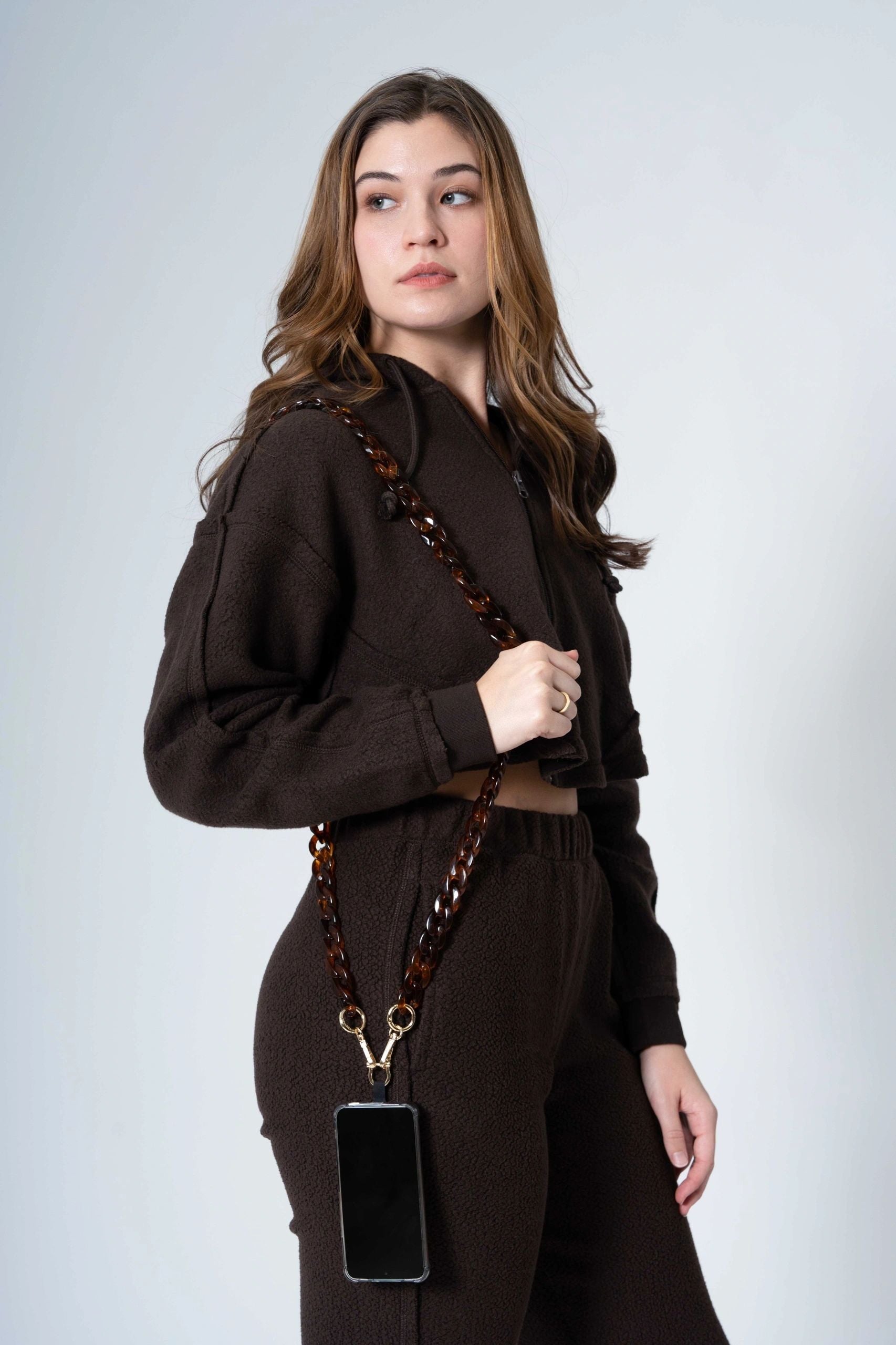 dark Brown Resin link long Chain with Golden Carabiners attached to a phone worn by a lady on her shoulder