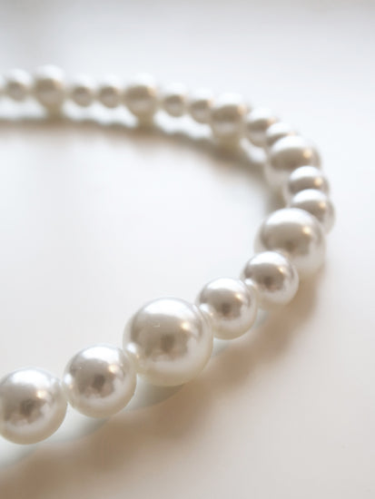 detail of A short white pearl chain 