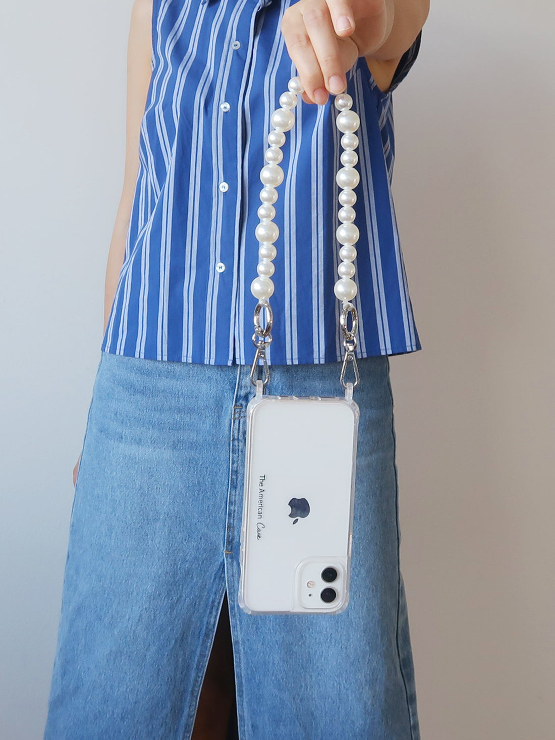A short white pearl chain attached to phone hold by a lady