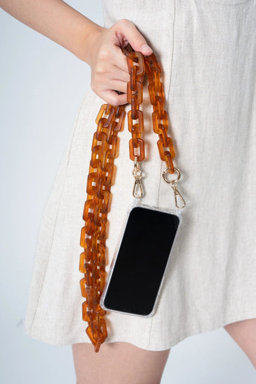 matte brown resin long phone chian held by a lady.